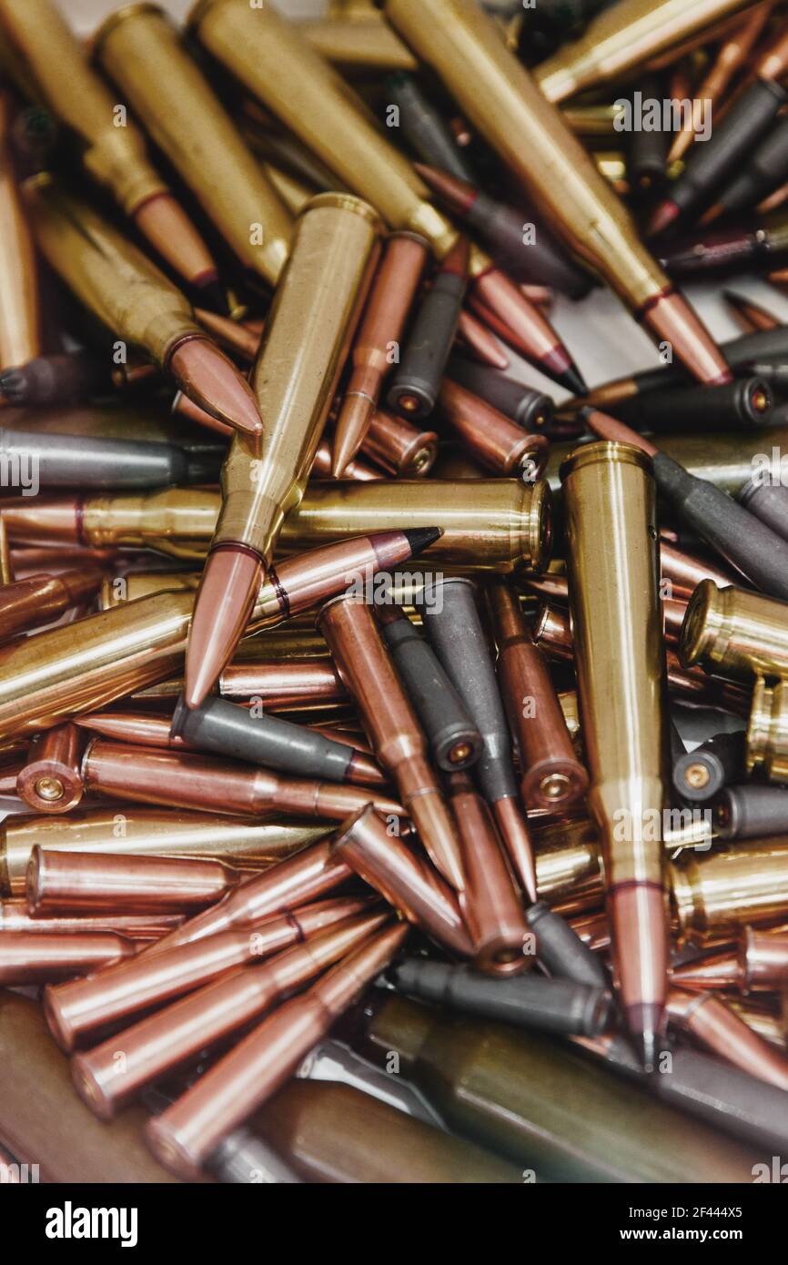 Haufen von Kugeln mit Kupferspitzen unter einem warmen Licht. Nahaufnahme von vielen Kugeln. Waffengewalt in Amerika. Stockfoto