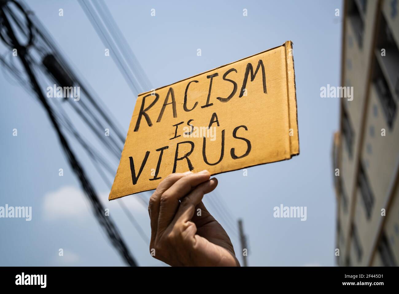 Ein Mann hält Rassismus ist ein Virus-Zeichen Stockfoto