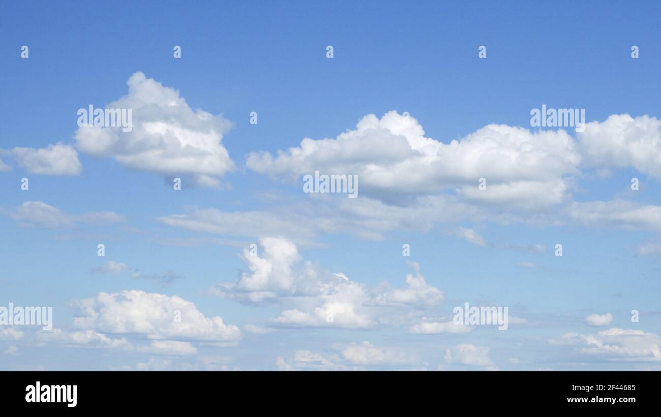 Cumulus weiße Wolken gegen einen klaren blauen Himmel bei sonnigem Wetter. Hintergrund. Stockfoto
