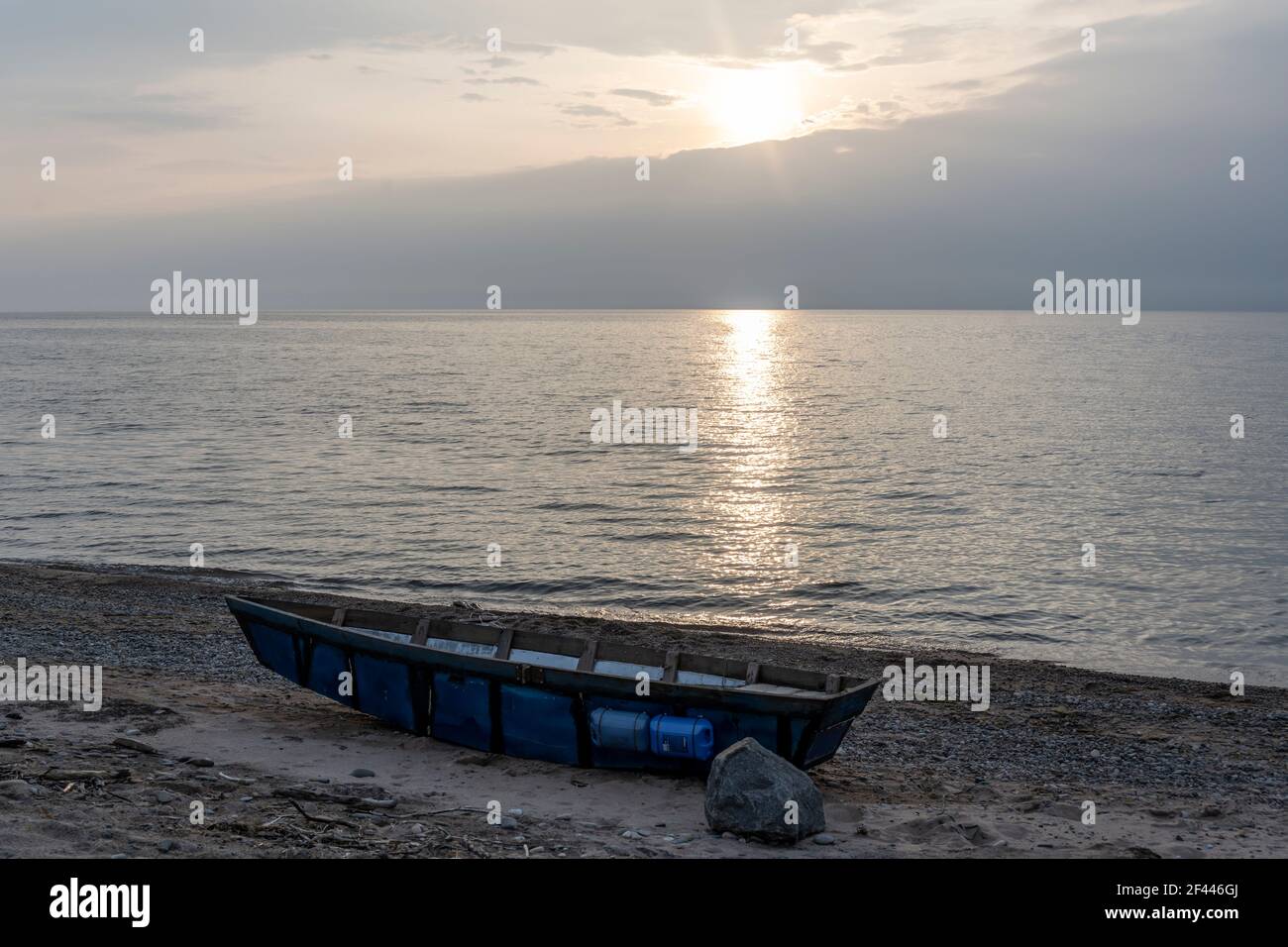 Sonnenuntergang am Baikalsee in Sibirien, Russland, mit einem Boot am Strand. Stockfoto