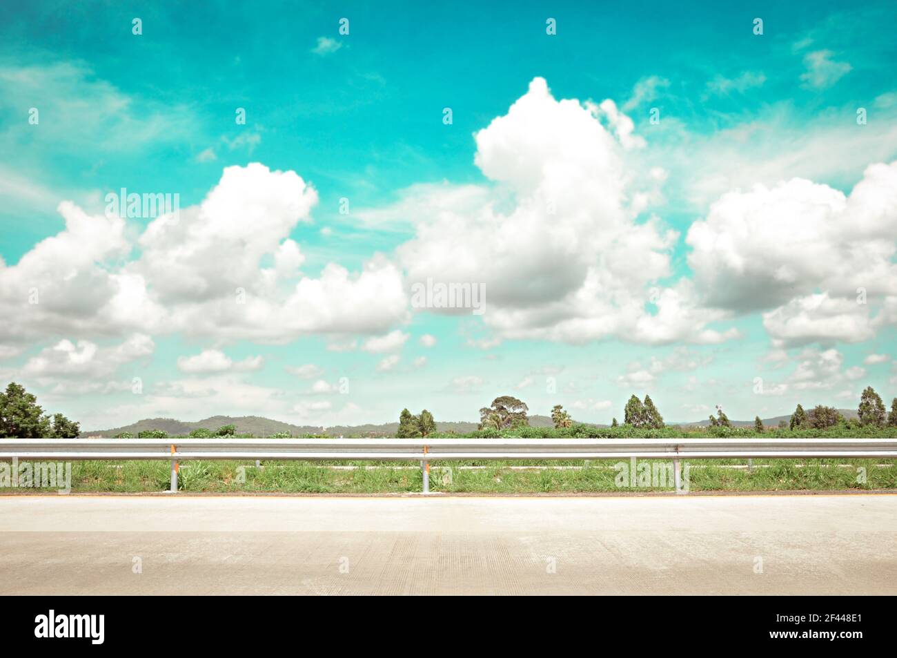 Blick auf die Straße mit grüner Natur, Wolken & Himmel - Retro-Stil Lichteffekt Stockfoto