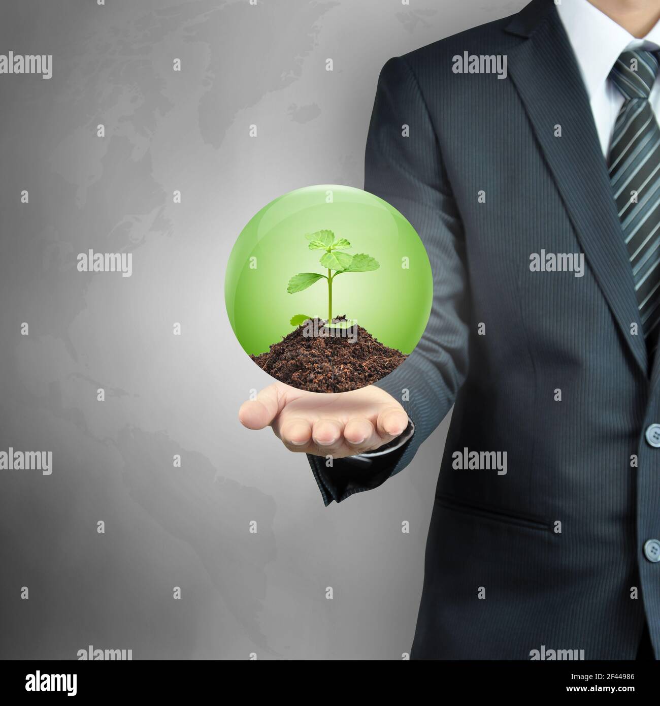 Geschäftsmann trägt grüne Sprössling mit Erde in der Kugel - Nachhaltige Entwicklung & Naturschutz Konzept Stockfoto