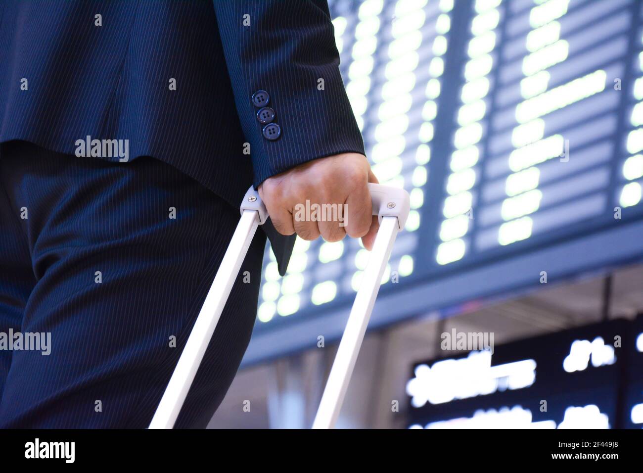 Geschäftsmann vor dem Flughafen Fahrplan mit Trolley Tasche Stockfoto