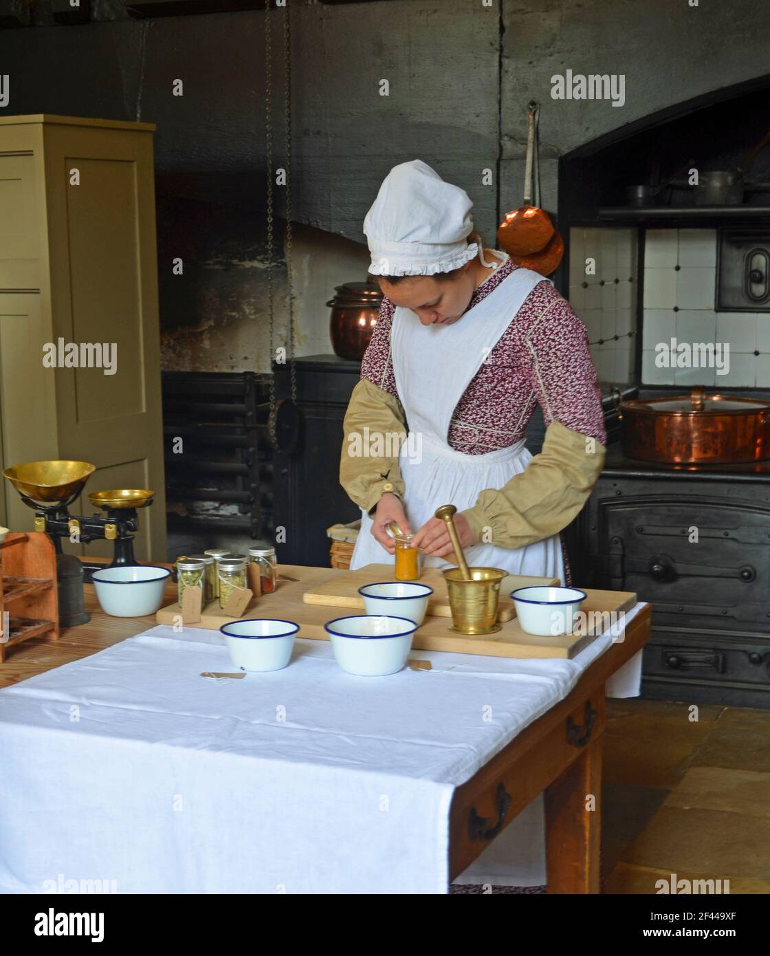 Viktorianische Küche mit Frau gekleidet als viktorianische Küche Zimmermädchen arbeiten. Stockfoto