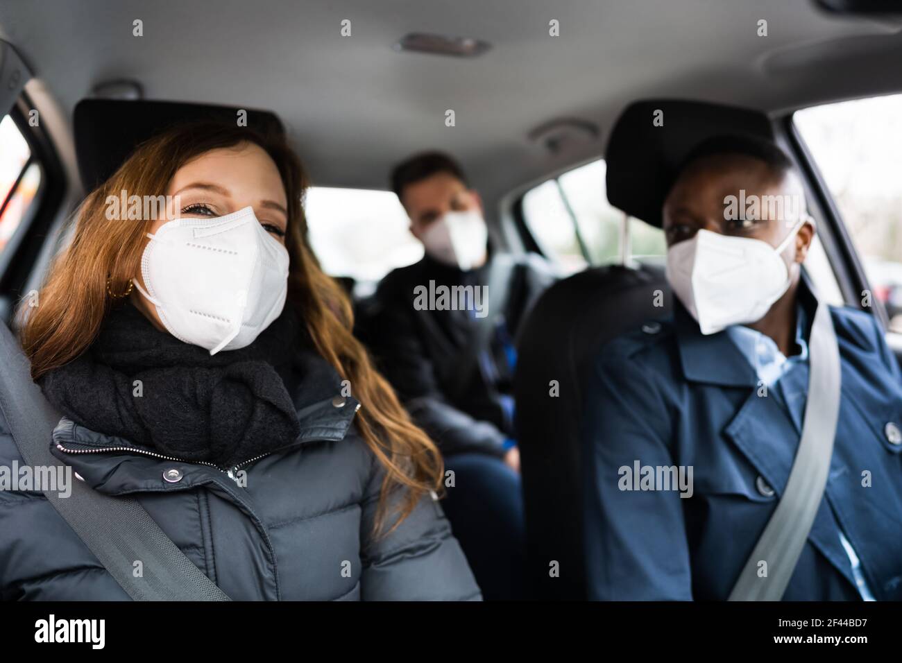 Carpool Ride Share. Freunde Genießen Taxi In Face Mask Stockfoto