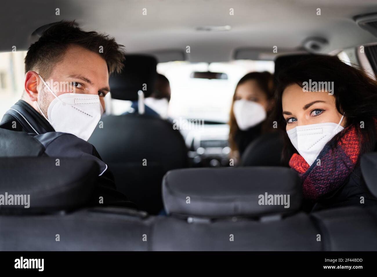 Carpool Ride Share. Freunde Genießen Taxi In Face Mask Stockfoto
