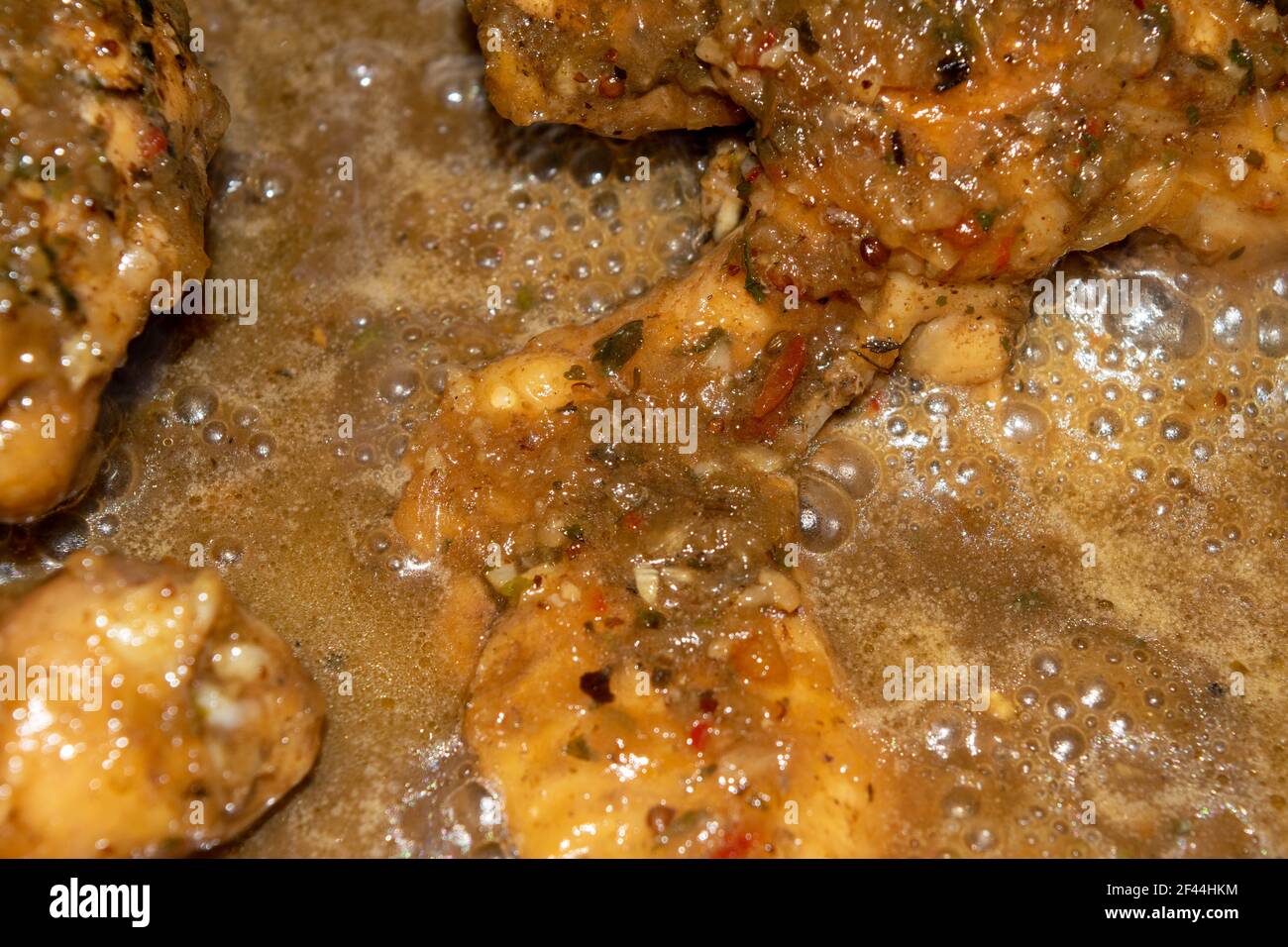 Kleine Stücke Hühnerfleisch werden mit Gewürzen geschmort. Nahaufnahme mit selektivem Fokus. Stockfoto