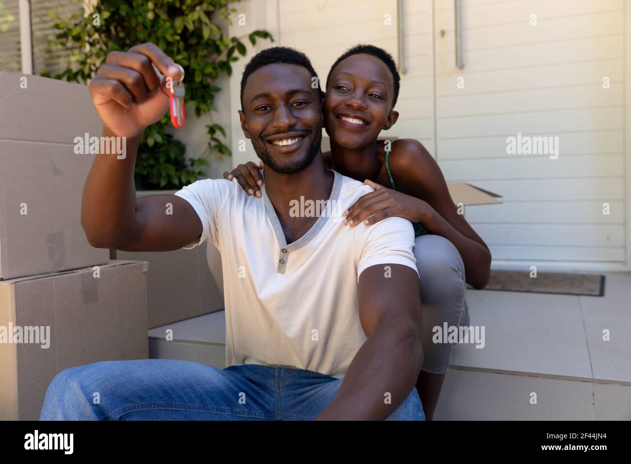 Porträt von afroamerikanischen Paar Umzug Haus mit Schlüsseln und Lächelnd Stockfoto