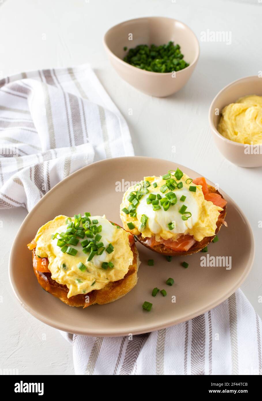Leckeres herzhaftes Frühstück, Eier Atlantic in einem Teller auf weißem Hintergrund, Runde gebratene Brötchen mit Lachs und Eier Benedikt, Sauce Hollandaise Stockfoto