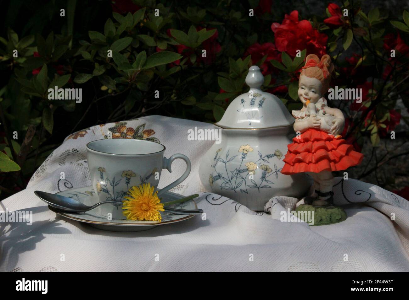 Couchtisch mit Tasse und antiken Zucker Schüssel bereit für Kaffee, zwischen bunten Blumen und Vintage-Dekorationen Stockfoto