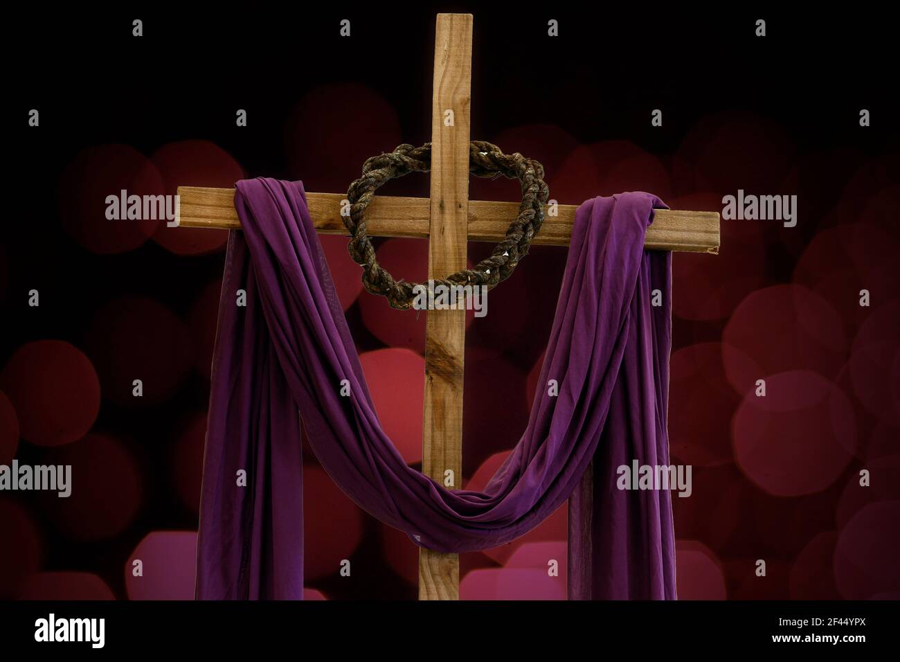 Holzkreuz mit Dornenkrone und violettem Stoff, katholische Symbole, Zeit der Fastenzeit Stockfoto
