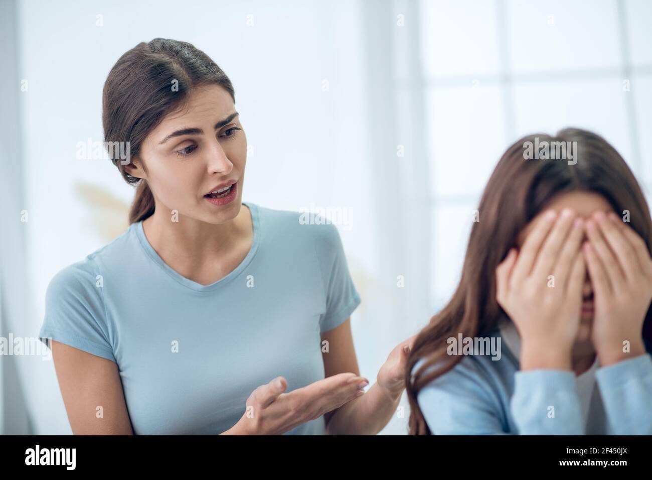 Aufmerksame, sachkundige Mutter, die mit der abgewandt Tochter sprach Stockfoto