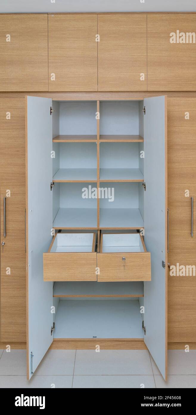 Ein Holzschrank mit offenen Türen und Regalen Stockfoto