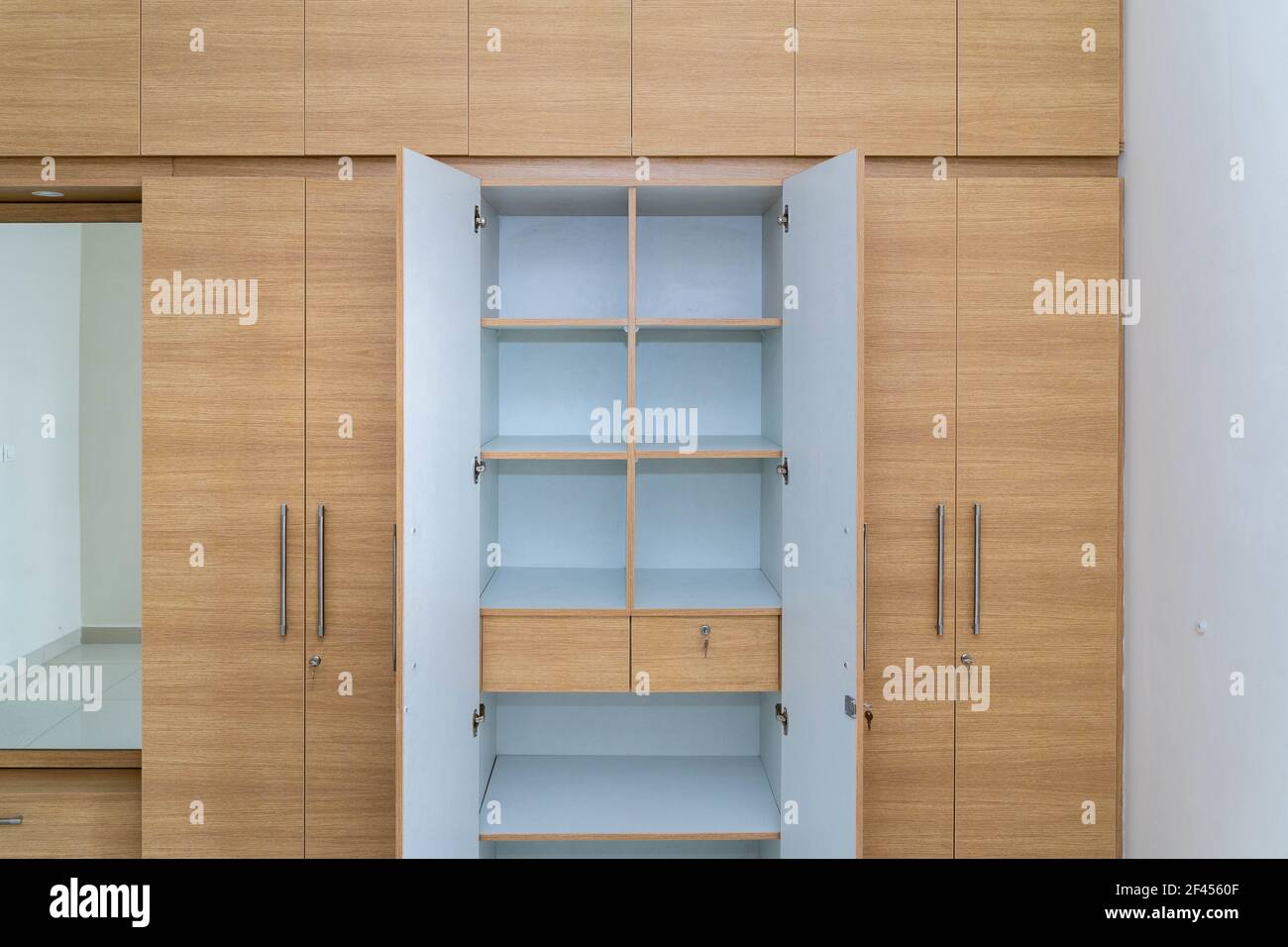 Ein Holzschrank mit offenen Türen und Regalen Stockfoto