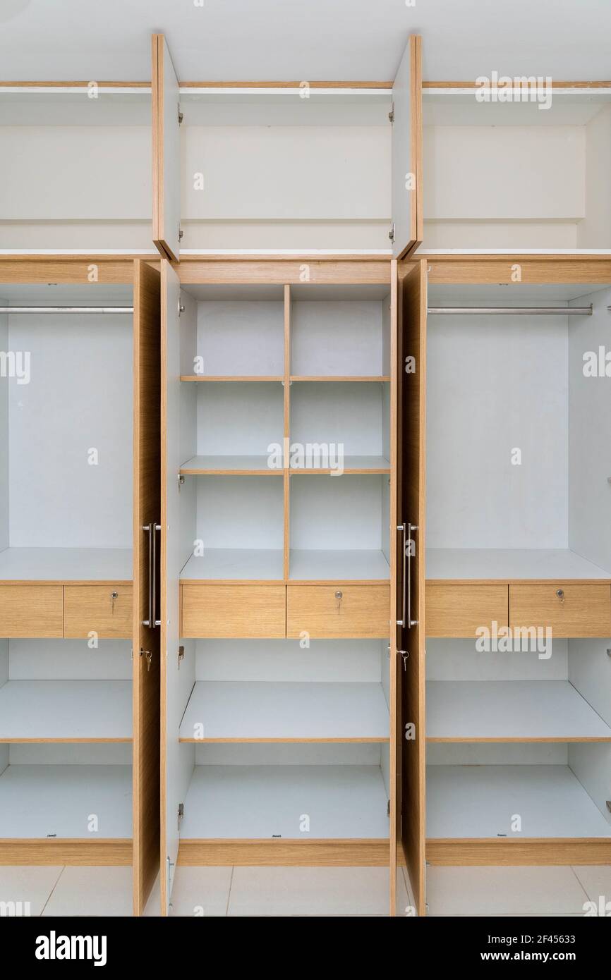 Ein Holzschrank mit offenen Türen und Regalen Stockfoto