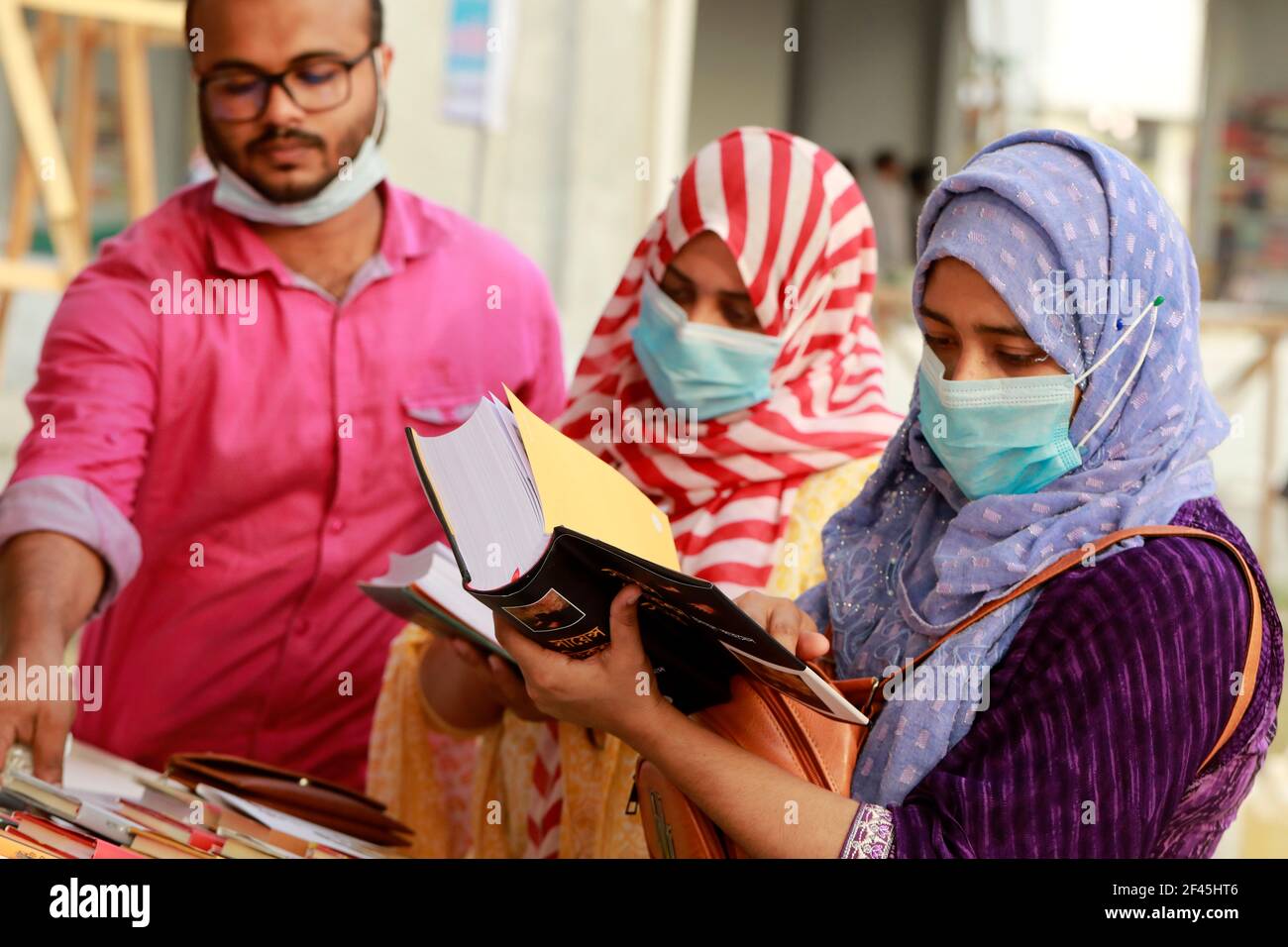 Dhaka, Bangladesch - 18. März 2021: Besucher stöbern in Büchern an einem Stand der Ekushey Book Fair in Suhrawardy Udyan in Dhaka. Die Messe, traditionell organi Stockfoto