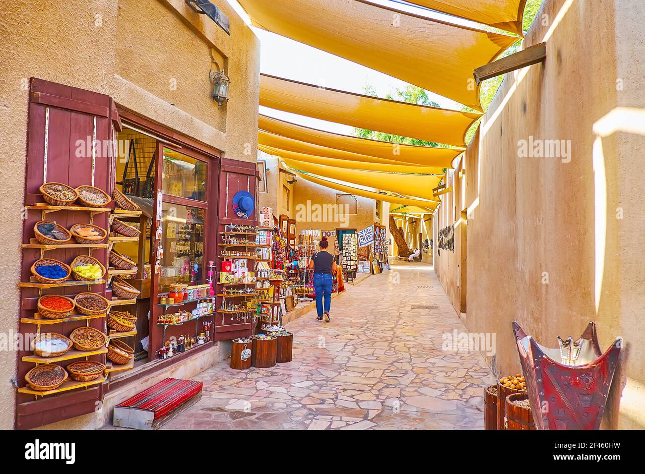 Spazieren Sie durch die enge schattige Straße von Al Fahidi und genießen Sie die Gewürz-, Teppich- und Souvenirläden von Al Souk al Kabir (Alter Markt), Dubai, VAE Stockfoto