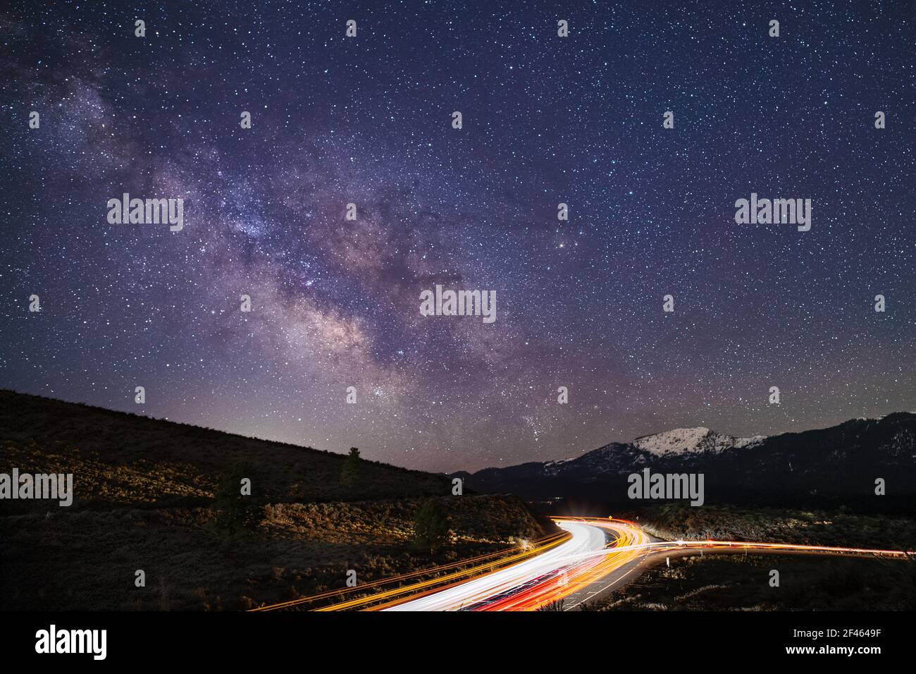 Leichte Spuren des Autobahnverkehrs Streifen in Richtung und von der Milchstraße Kern. US Highway 395 bei Bass Hill, Lassen County, Kalifornien, USA. Stockfoto