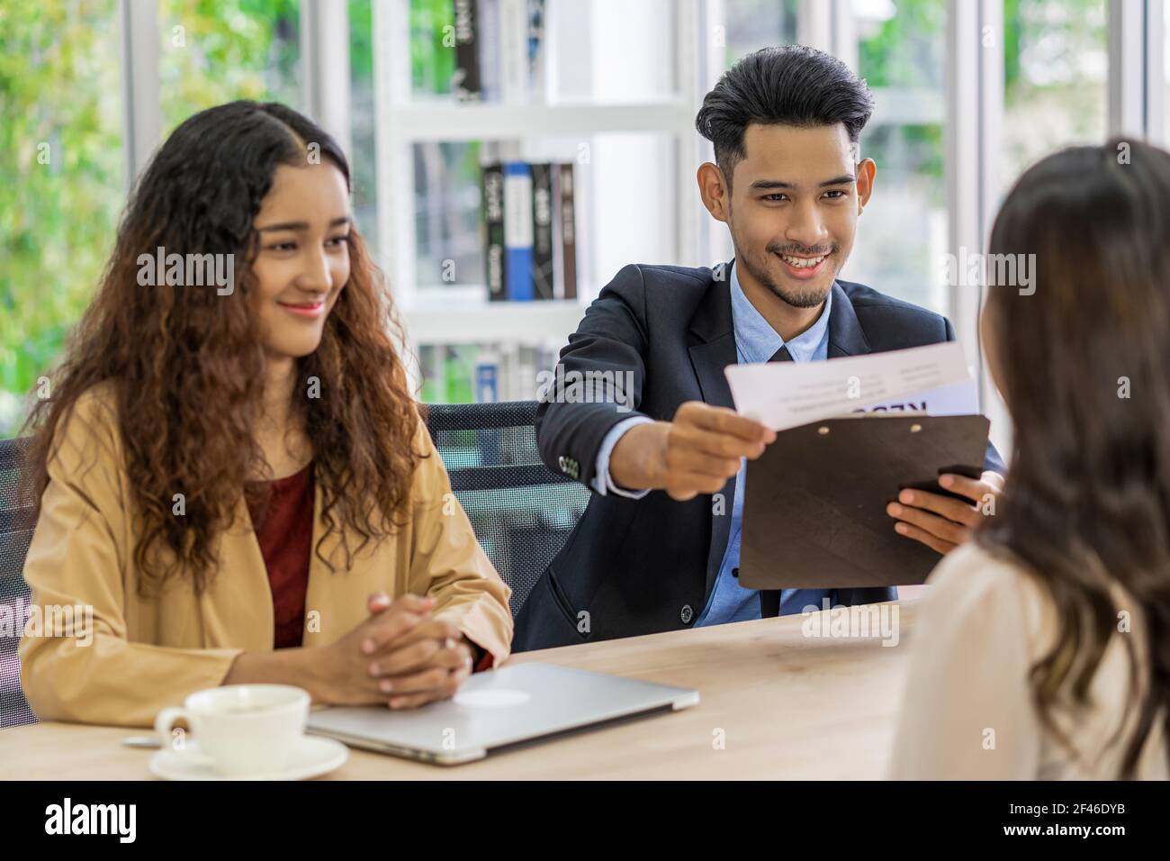 Senior Asian Manager erklärt oder beantwortet die Stellenbeschreibung und Vorteile für junge asiatische Frau Absolvent mit positiver Bewegung in Tagungsraum, Bus Stockfoto