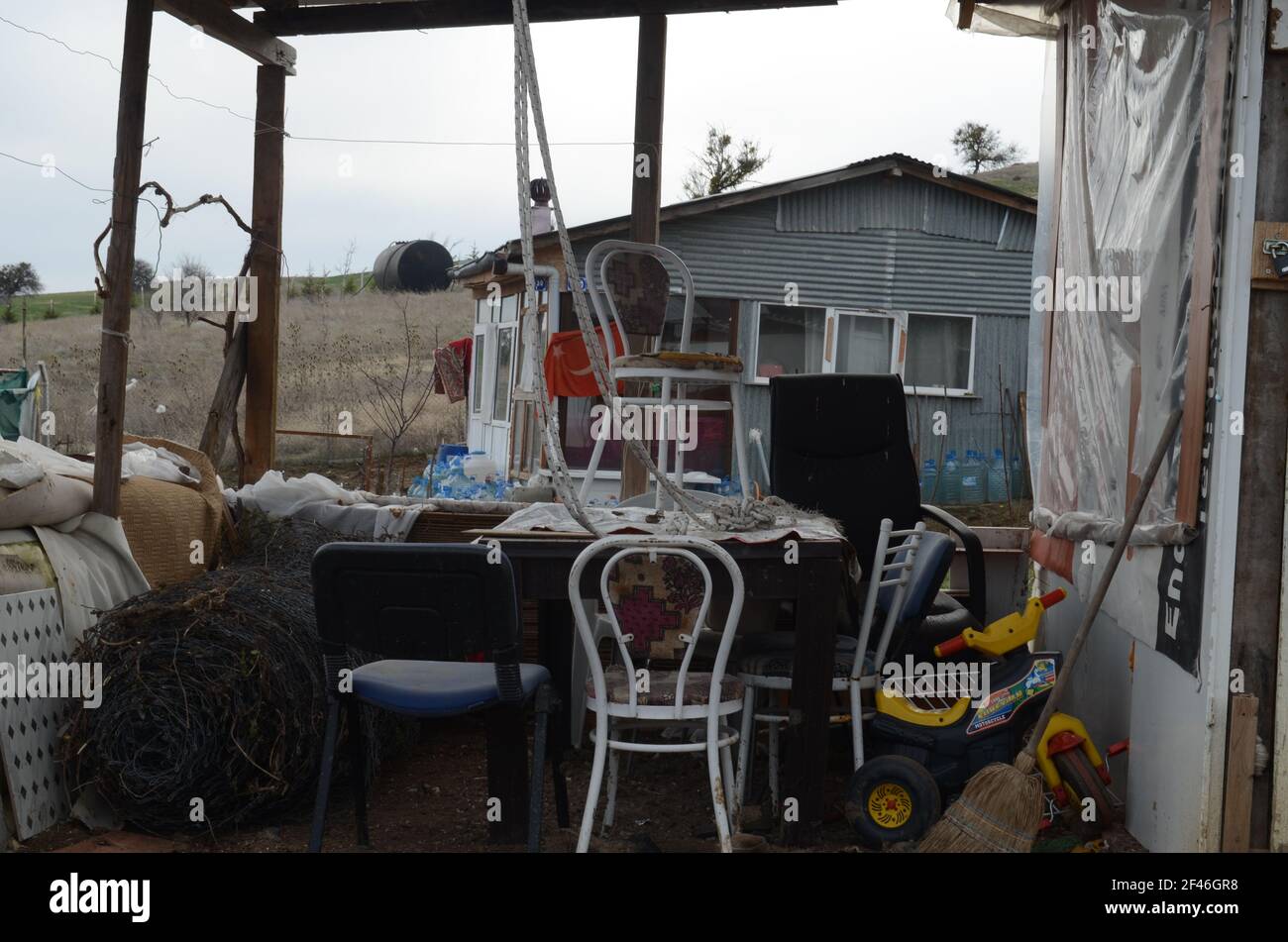 Der Garten eines schmutzigen, chaotischen Hauses voller Dinge. Hausbesetzer. Stockfoto