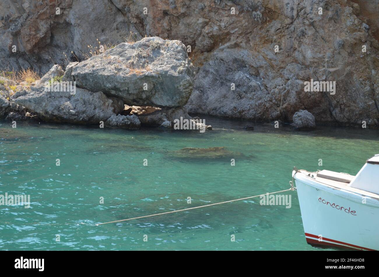 Türkisfarbenes Meer, ein weißes Boot. Stockfoto