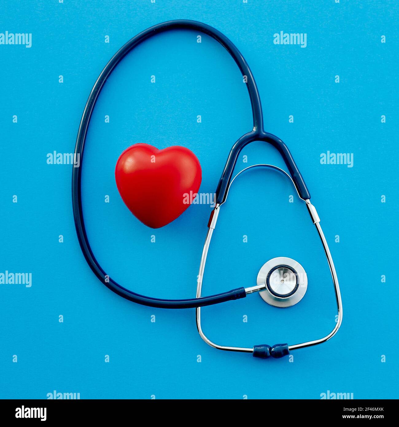Stethoskop und ein rotes Herz auf blauem Hintergrund. Stockfoto