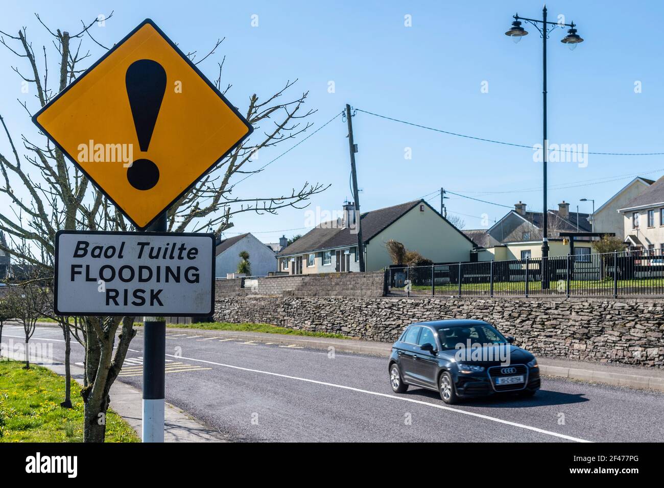 Hochwasserrisikowarnschild in Timoleague, West Cork, Irland mit fahrenden Wagen. Stockfoto