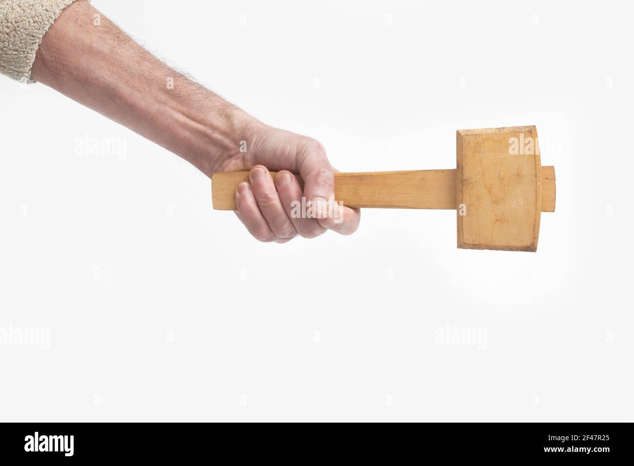 Eine mans Hand hält einen Holzhammer Stockfoto