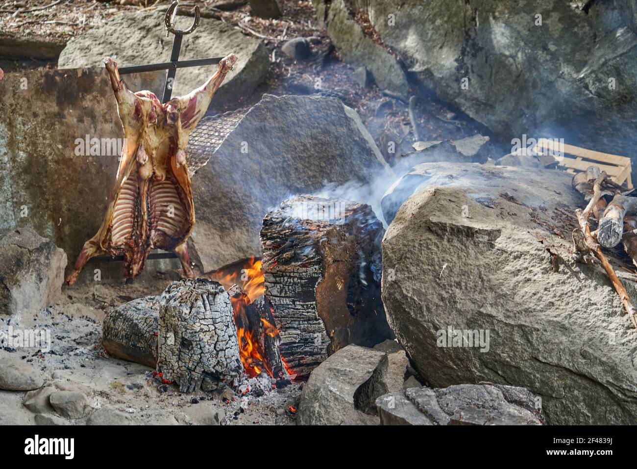 Rustikales Lamm Grill bbq über offenem Feuer in Patagonien, Argentinien, Südamerika. Asado ist ein Gaucho Traditon mit Kochen auf offener Flamme Stockfoto