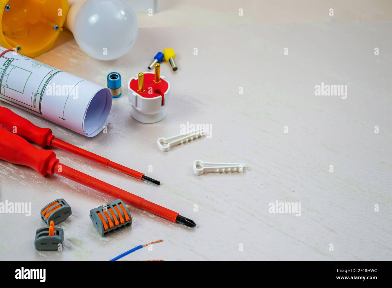 Flache Komposition mit Elektroinstallateur-Werkzeugen auf weißem Hintergrund. Für Text platzieren. Selektiver Fokus. Stockfoto