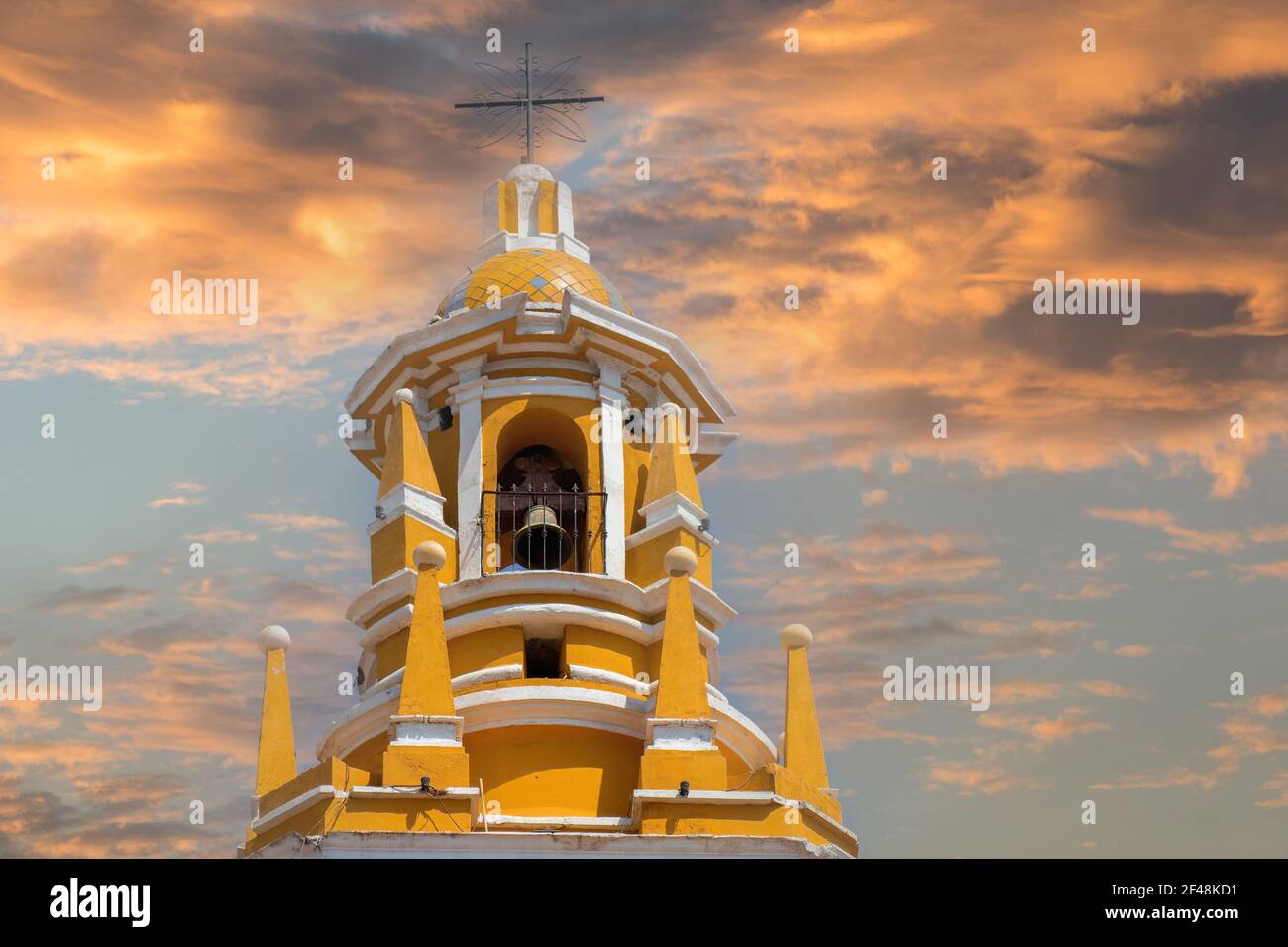 Eine schöne Aufnahme des Glockenturms aus dem Kloster des Erzengels San Gabriel in Cholula, Mexiko mit dem wunderschönen Sonnenuntergang Himmel im Hintergrund Stockfoto