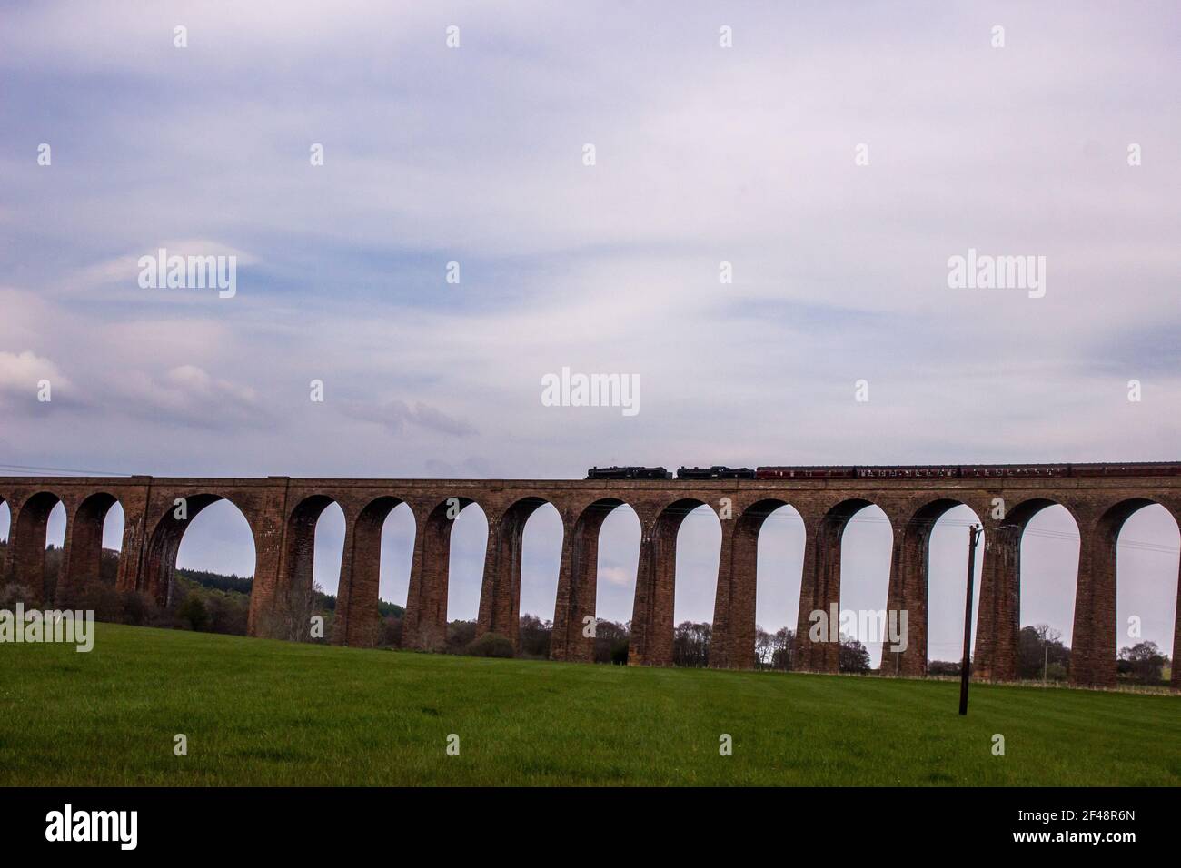 Ein Dampfzug, der das Viadukt von Culloden überquert, ein Eisenbahnviadukt, wo er den Fluss Nairn im Norden der schottischen Highlands überquert Stockfoto