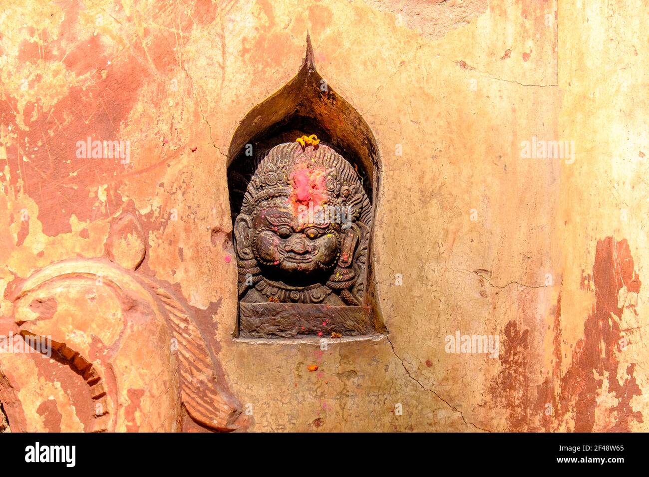 Schnitzerei einer hinduistischen Gottheit in einer Nische eines Tempels in Kathmandu, Nepal Stockfoto