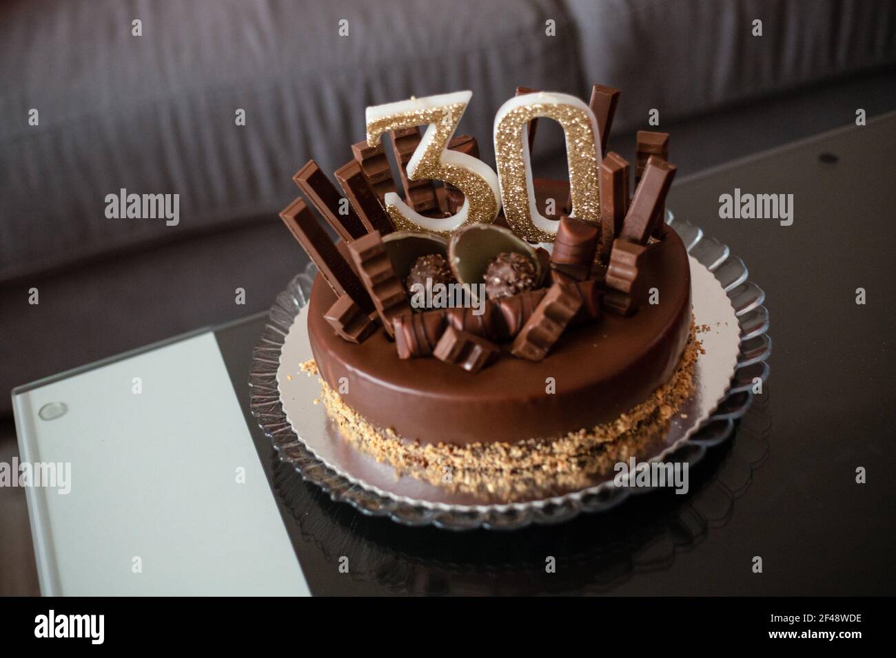 Eine Nahaufnahme eines leckeren Geburtstags-Schokoladenkuchen mit Nummer 30 Kerzen oben Stockfoto