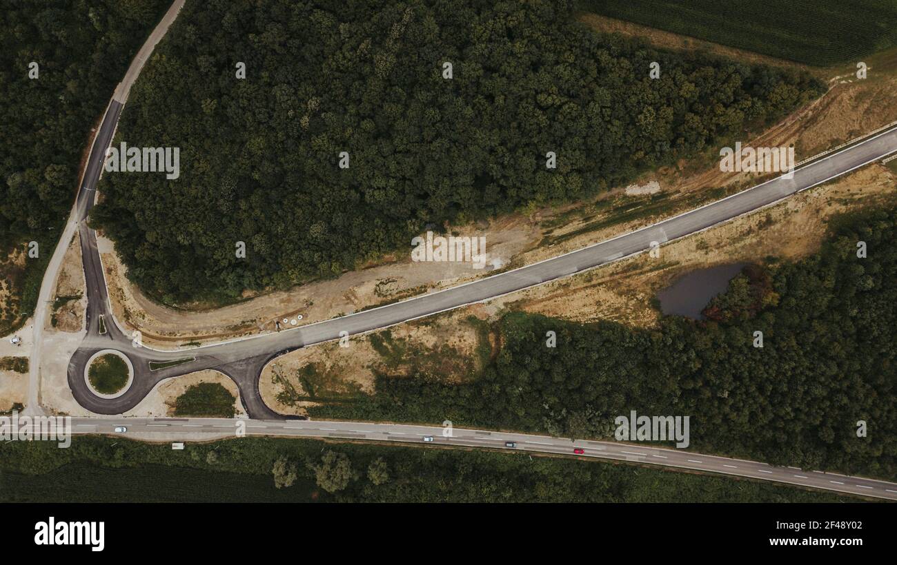 Ein Lufthof eine Straße im Bau, umgeben von Wald im Bezirk Brcko, Bosnien und Herzegowina Stockfoto