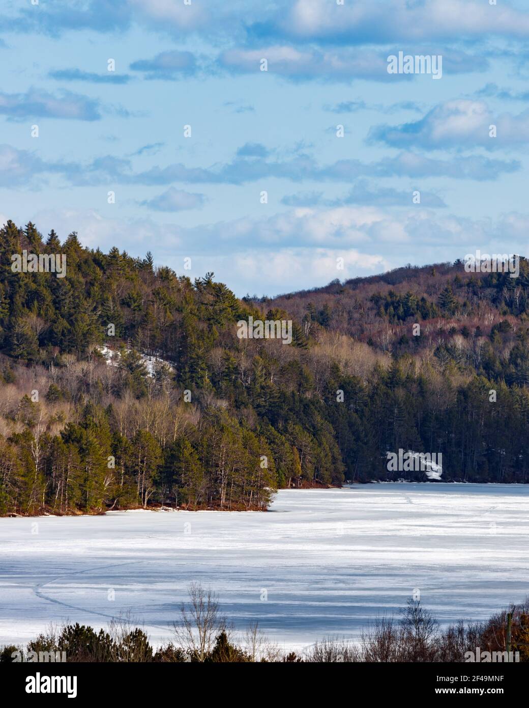 Ein Blick aus der Höhe auf Carson Lake, Ontario und die umliegenden Hügel. Die Oberfläche des Wassers ist im Spätwinter noch gefroren. Stockfoto