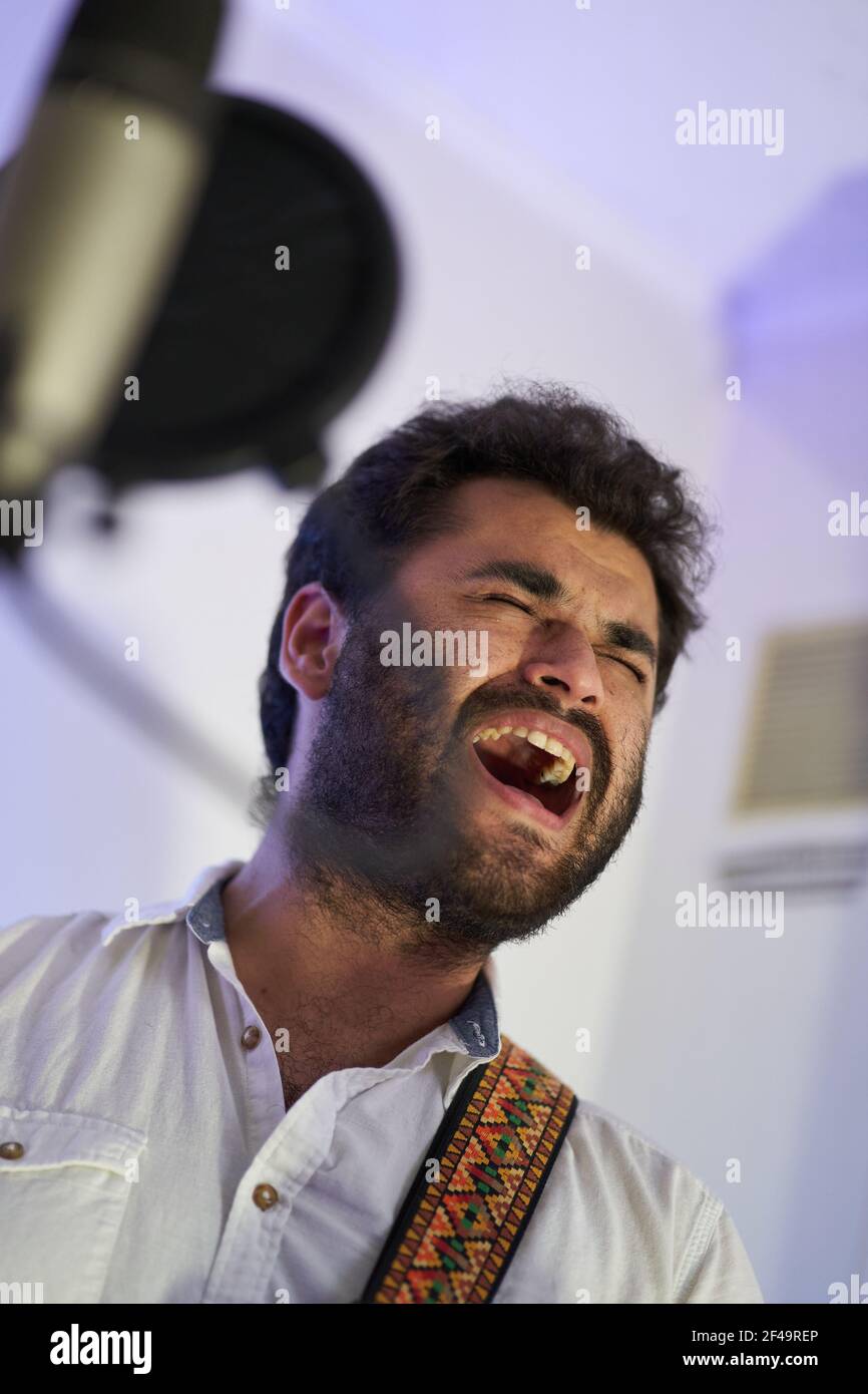Ein professioneller leidenschaftlicher Musiker mit E-Gitarre, der begeistert singt Und Aufnahmen im Studio Stockfoto