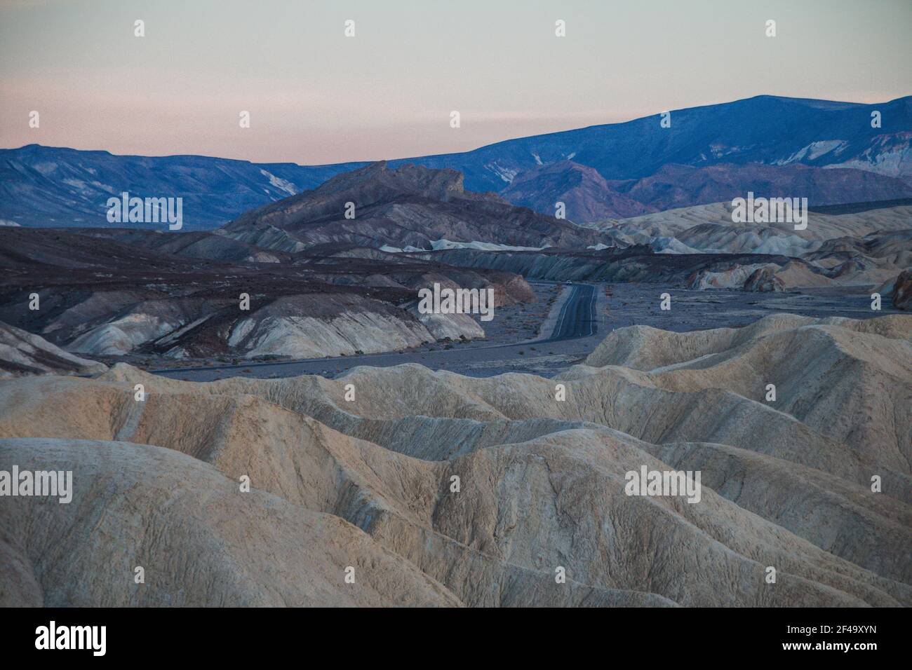 Zabriskie Punkt bei Sonnenuntergang, mit einer leeren Straße in der Ferne Stockfoto