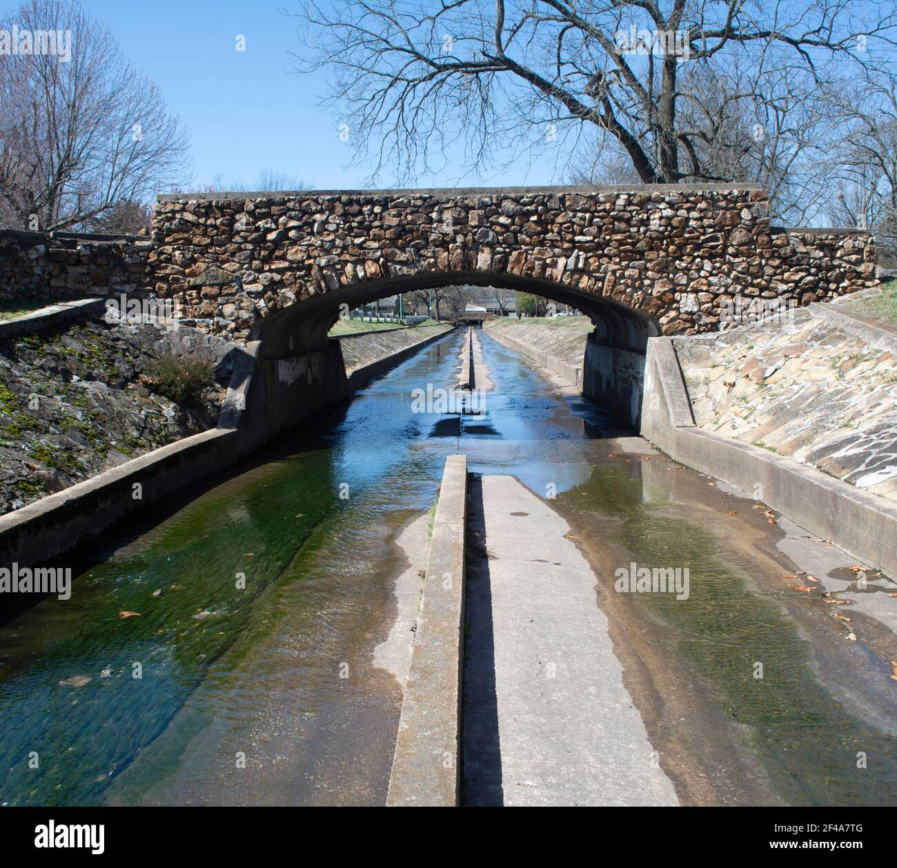 Eine jahrhundertealte Felsbrücke überspannt den Fassnight Creek auf der Südseite des Phelps Grove Parks in Springfield, Missouri. Stockfoto