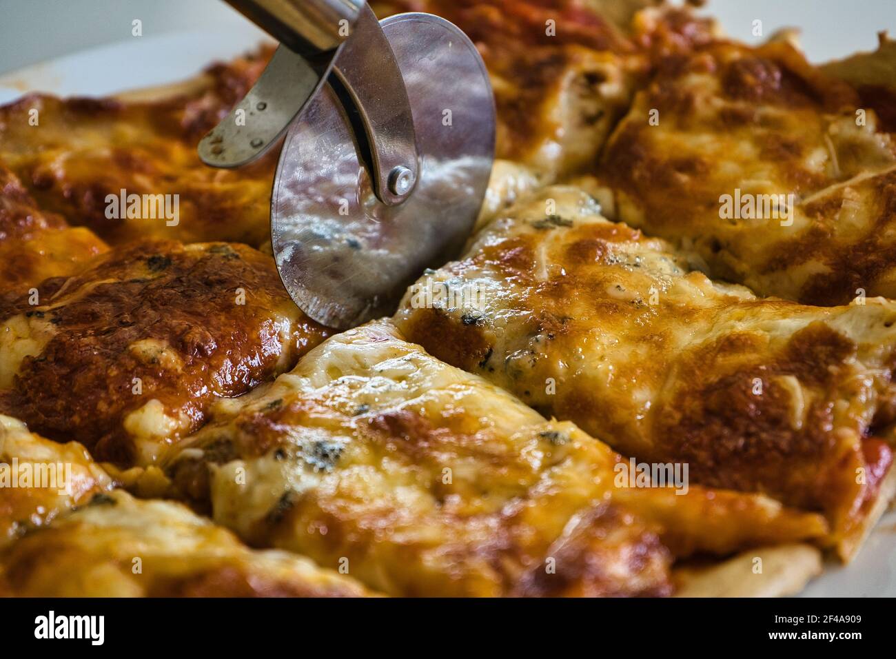 Köstliche hausgemachte heiße italienische Pizza bereit zu essen. Mit Tomaten, Schinken, Mozzarella und vier Käsesorten. Geschmack Stockfoto