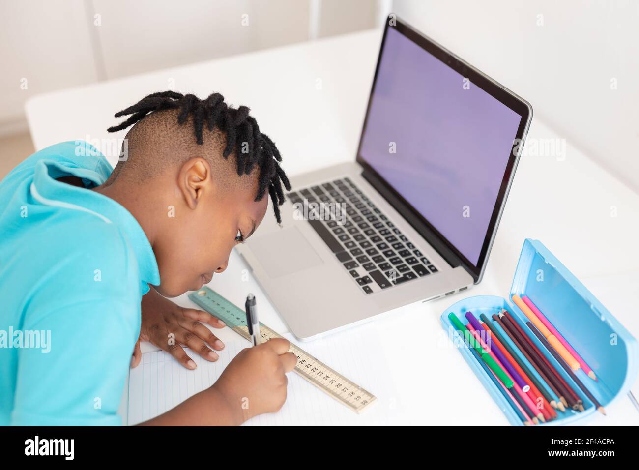 afroamerikanischer Junge am Schreibtisch mit Laptop mit Kopierplatz Für Online-Schulunterricht Stockfoto