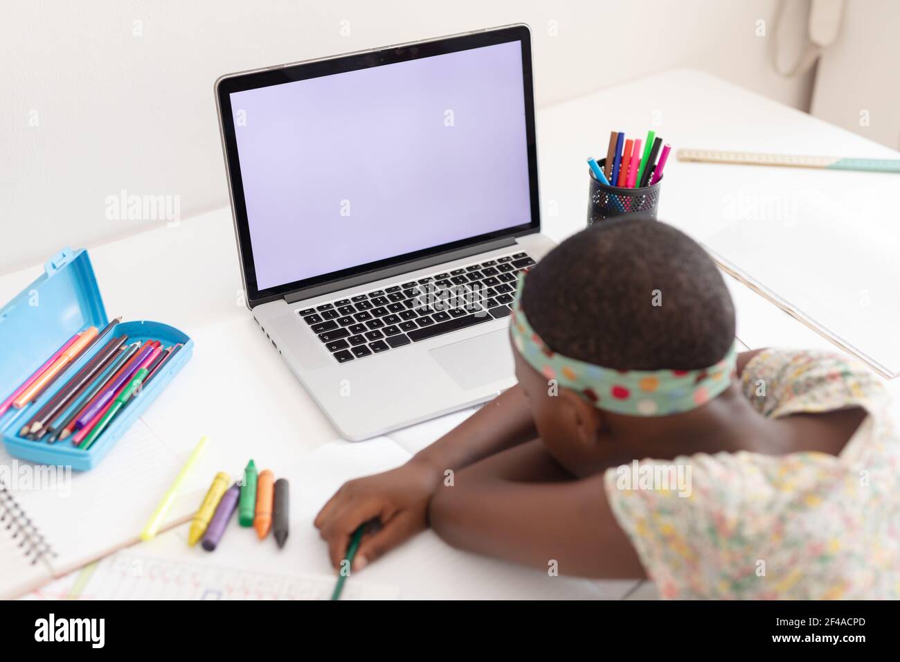afroamerikanische Mädchen im Schlafzimmer sitzen am Schreibtisch mit Laptop Für Online-Schule ruhenden Kopf auf Armen Stockfoto