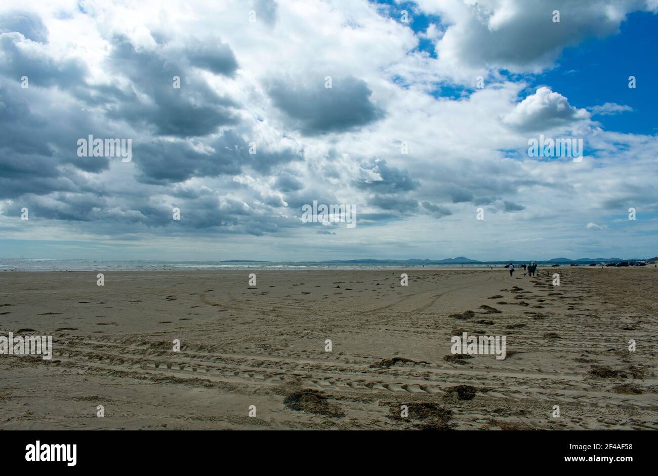 Black Rock Sands, Pothmadog, Wales. Dramatischer Himmel, makelloser Sandstrand. Ein heller Sommertag. Entfernte Berge von Snowdonia am Horizont. Walisische SE Stockfoto