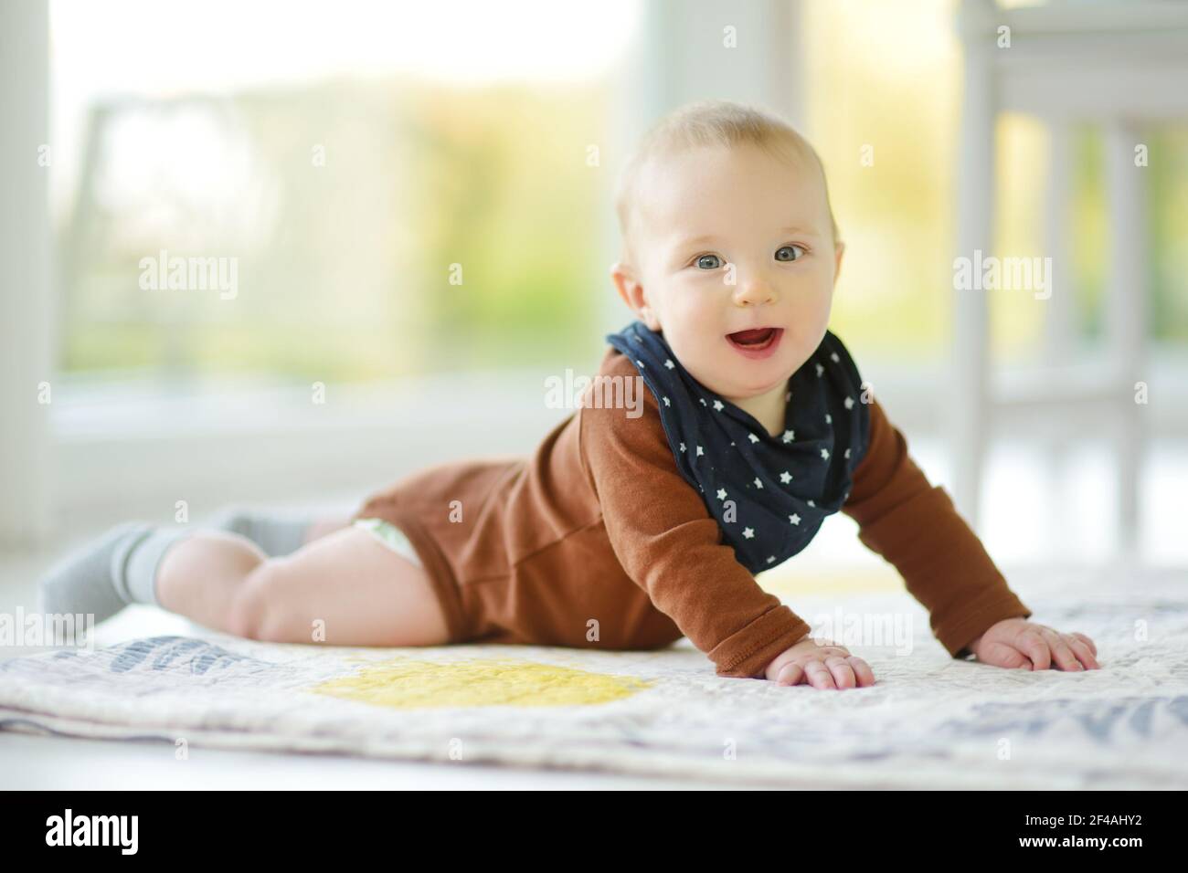 Niedlicher fünf Monate alter Junge, der auf seinem Bauch liegt. Baby während der Bauchzeit. Nettes kleines Kind lernen zu kriechen. Stockfoto