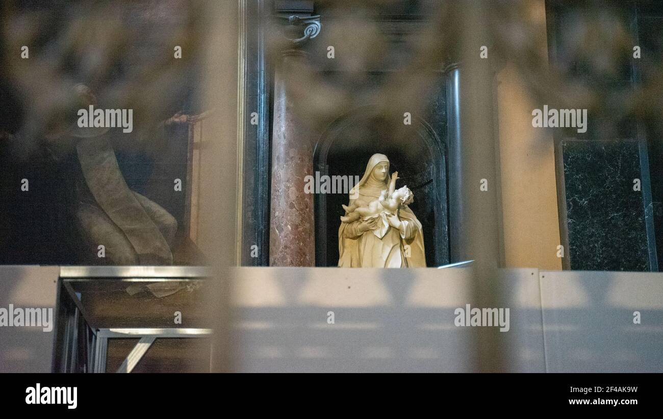 Kleine Statue der Jungfrau Maria und des Kindes in der katholischen Kathedrale in Krakau, Polen, umrahmt von unscharfen Marmorelementen der Inneneinrichtung. Stockfoto