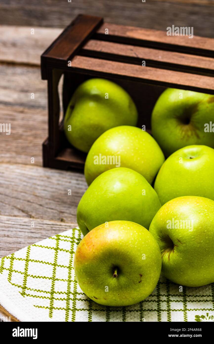 Eine hölzerne Kiste mit reifen grünen Äpfeln auf einem hölzernen Tabelle Stockfoto
