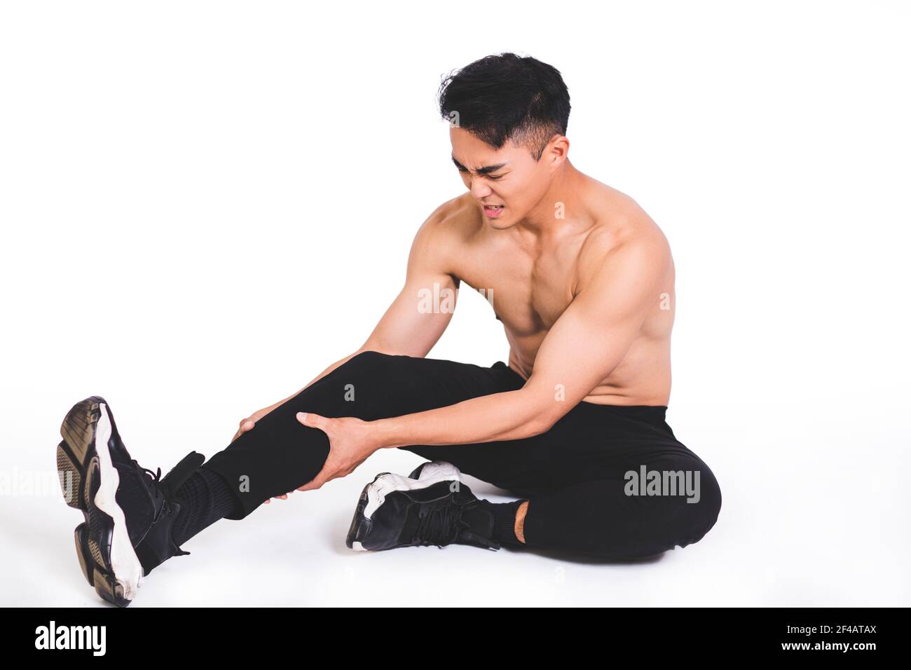 Muskelfitness Mann, der nach seinem Bein in den Schmerz greift Stockfoto