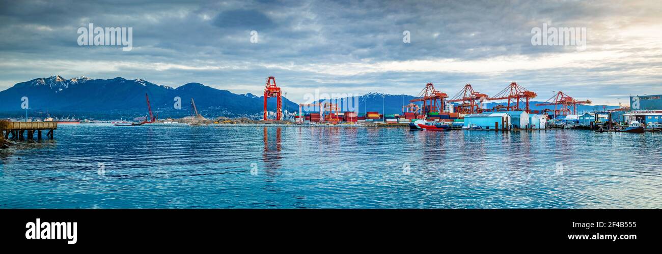 Dramatisches Panorama des Hafens von Vancouver, am frühen Morgen mit Wolken. Waterfront Szene mit Industriegebäuden, Kräne, Frachtcontainer, Großtanker, b Stockfoto