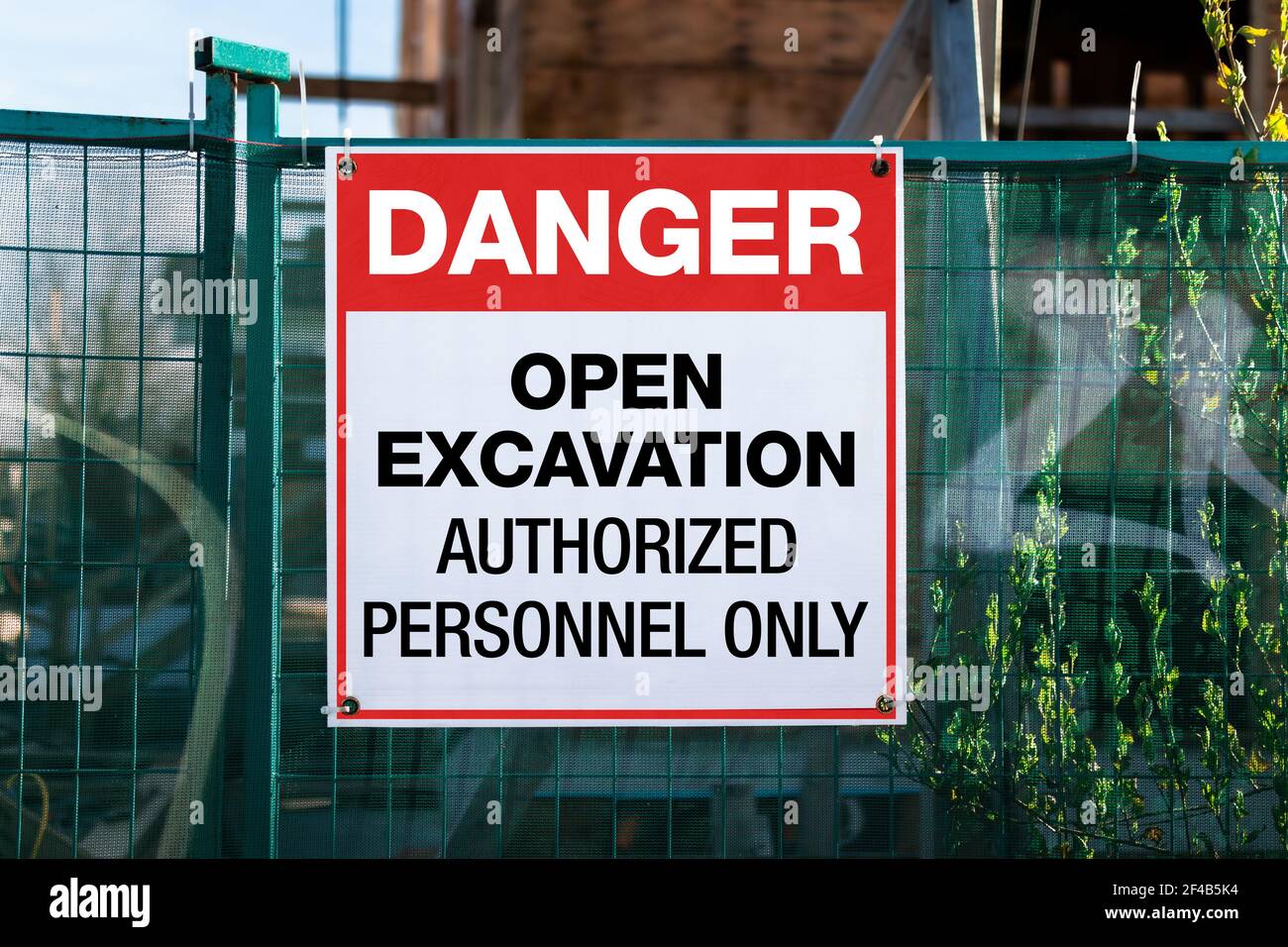 Baustellen-Sicherheitsbeschilderung mit Text: Gefahr, offene Aushub, nur autorisiertes Personal. Großes Schild oder Plakat auf grünem Bauzaun. Stockfoto