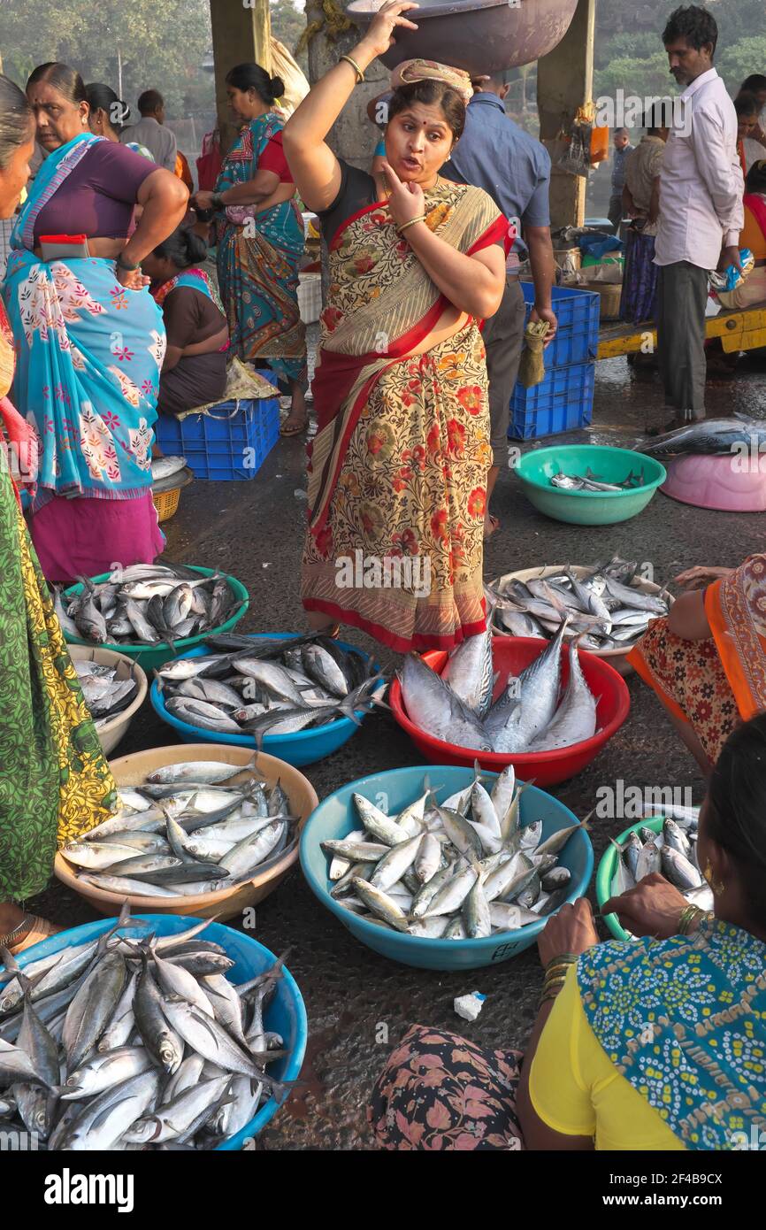 Eine Frau der Koli-Volksgruppe, die Fisch in Sassoon Docks, einem Fischerhafen in Colaba, Mumbai, Indien, transportiert und verkauft Stockfoto